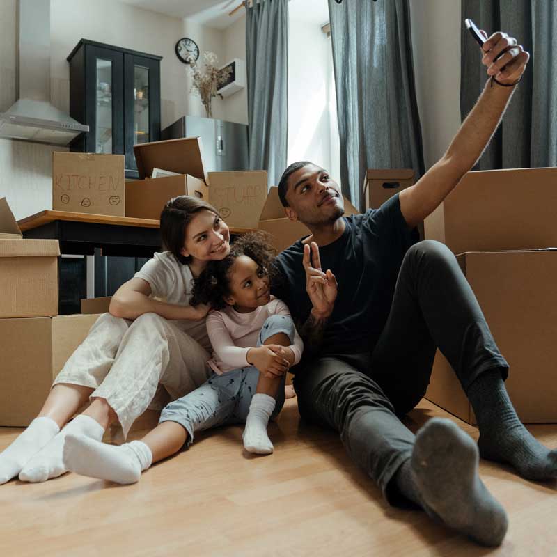 Photo of man woman and girl taking a selfie in front of empty boxes